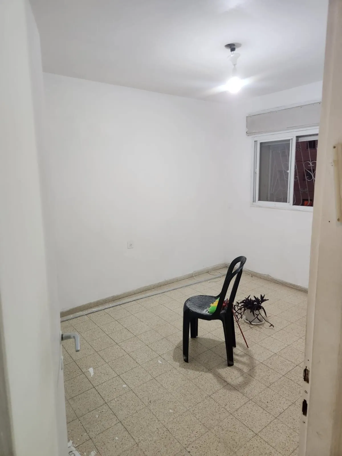 חדר עם קירות לבנים וריצוף ישן לפני ההנחה